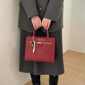 Détail du sac bandoulière bordeaux avec texture à chevrons et perles en bois colorées