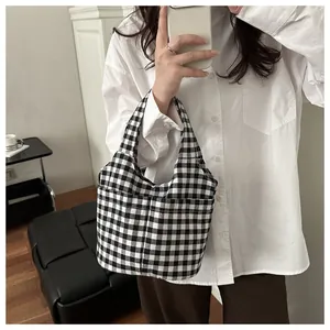 Détail du sac cabas à carreaux avec deux poches avant et motif vichy noir et blanc classique