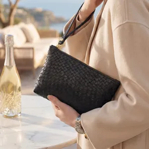 Classic black woven leather clutch bag with gold zipper detail and wrist strap for women