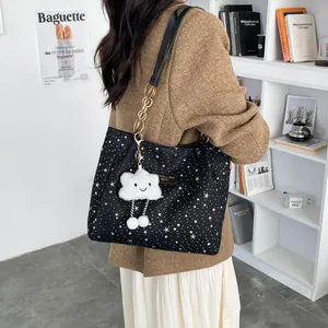 Star pattern tote bag with gold chain strap and cloud charm shown in indoor setting
