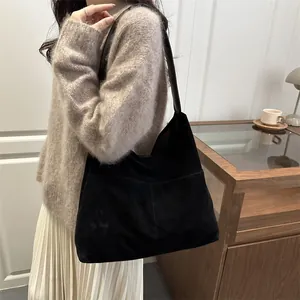 Borsa tote nera opaca da donna indossata a spalla in un elegante contesto casual quotidiano
