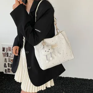 Chic white tote bag with silver star patterns and cloud charm shown on shoulder