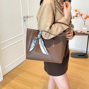 Sac cabas en cuir marron avec un élégant foulard fleuri sur l'anse pour femme