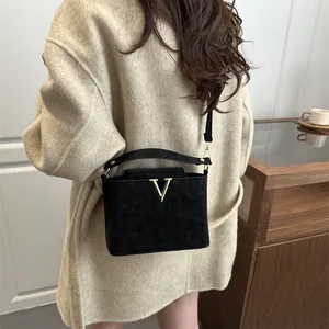 Chic black matte square crossbody bag with gold V-shaped logo for stylish women