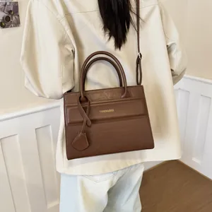 Brown vintage square handbag with crocodile embossing and golden Fashion logo lettering
