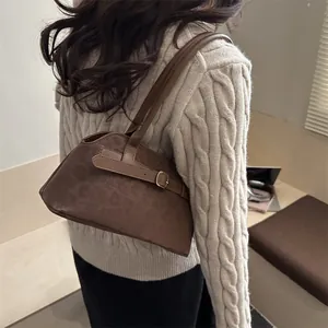Borsa sottobraccio vintage in pelle scamosciata marrone scuro con fibbia dorata su modella