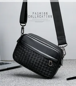 Détail de la texture en cuir tressé d'un sac bandoulière noir avec large sangle nylon