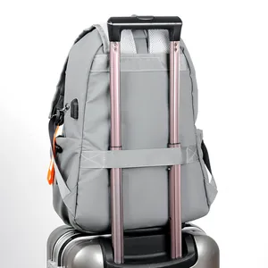 Gray travel backpack with luggage strap and USB charging port for laptops and college use
