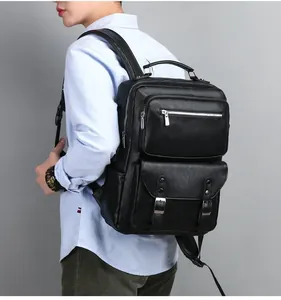 Side view of man carrying black leather business laptop backpack with silver metal buckles