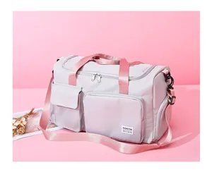 Bolsa de viaje fitness gris claro con correas rosas y bolsillos frontales sobre rosa