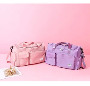 Detalle de bolsas de viaje rosa y lila en tela impermeable con correas de hombro