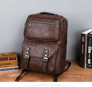 Detailed view of dark brown leather backpack compartments on a vintage wooden desk