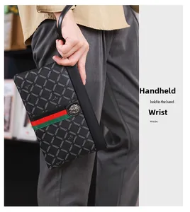 Detail van luxe zwarte lederen clutch met leeuwembleem en rood-groene strepen