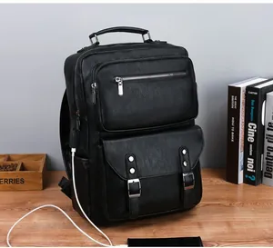 Detail of black leather business backpack featuring USB port and multi-layer texture