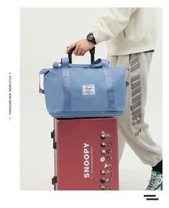 Blue waterproof travel bag with sleeve for suitcase handle shown on red luggage