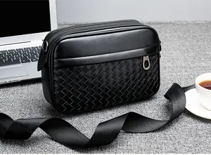 Détail de la texture tissée à la main sur un sac bandoulière noir pour homme, style professionnel