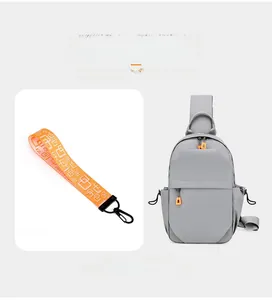 Detail of gray waterproof chest bag showing sleek zippers and orange decorative strap accessory