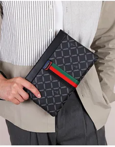 Detailweergave van de luxe lederen herenclutch met rood en groen gestreept weefsel
