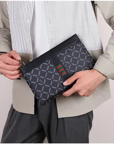 Detail of black leather clutch with checkered pattern and red-green striped webbing strap