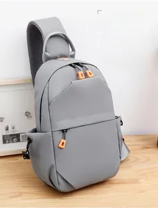 Detail of grey techwear sling bag featuring orange zippers and breathable mesh strap