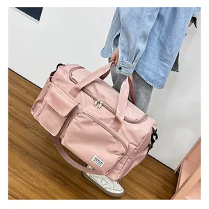 Detalle de la bolsa de viaje de nailon rosa resistente al agua con múltiples bolsillos