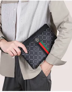 Detailed view of grey checkered clutch bag featuring a lion head emblem and red-green stripe