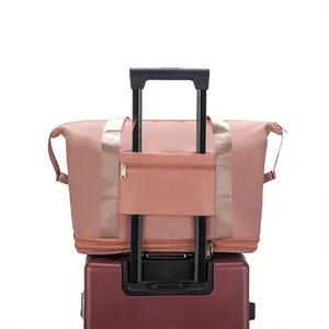 Pink waterproof travel bag with luggage sleeve and expandable base on a suitcase