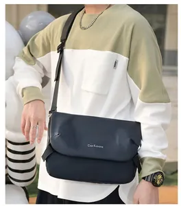 Close-up of minimalist black waterproof messenger bag with white branding on street
