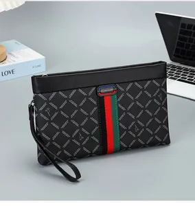 Detail van zwarte herenclutch met geometrische textuur en driekleurige geweven band
