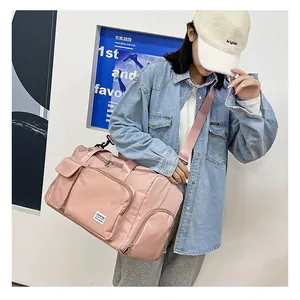 Detalle de bolsa de viaje rosa impermeable con etiqueta de marca y bolsillos con cremallera