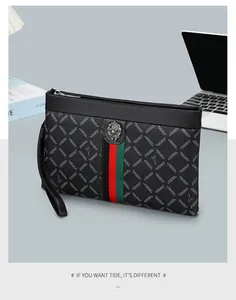 Macro detail of men's black leather clutch featuring a lion emblem and striped webbing
