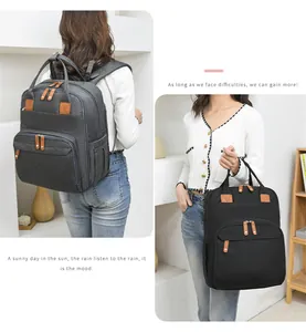Detail of multi-compartment diaper backpack in dark gray and black with leather pullers