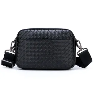 Sac à bandoulière en cuir tressé noir avec sangle large et boucles métalliques grises