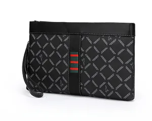 Detail of men's black clutch bag with embossed patterns and signature red-green stripe
