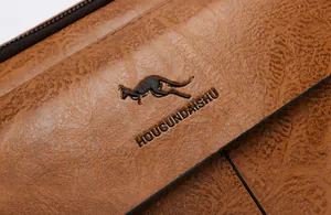 Nahaufnahme von braunem Leder mit Lychee-Struktur und geprägtem Känguru-Logo-Detail