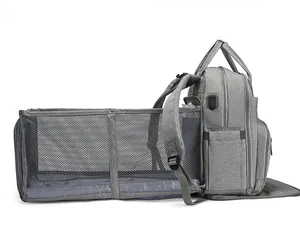 Detail of grey diaper bag expanding into a portable crib with breathable mesh side walls