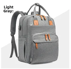 Detail of light gray diaper backpack showing fabric texture and external USB charging port