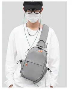 Detailed view of grey waterproof chest bag with orange zipper and side bungee cord