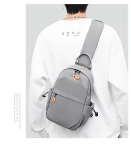 Macro detail of a grey crossbody bag featuring contrast orange zippers and side drawstrings