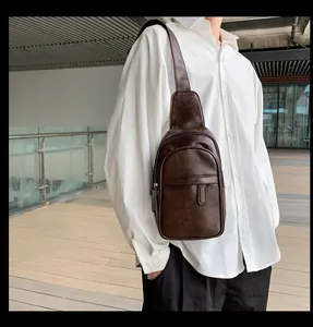 Detailaufnahme der dunkelbraunen Herren-Brusttasche mit Kieseltextur und Reißverschluss