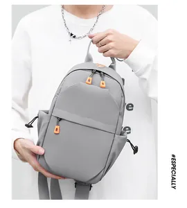 Detail of grey athletic chest bag featuring high-contrast orange zippers and compartments