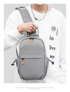 Close-up of grey waterproof crossbody chest bag with vibrant orange zipper details on model
