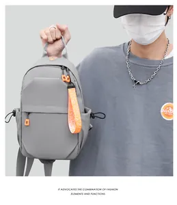 Detail view of large capacity gray nylon chest bag with vibrant orange zipper pulls