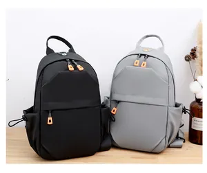 Close-up of black and grey tactical crossbody bags with vibrant orange zipper pulls
