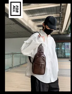 Mann mit brauner Leder-Brusttasche vor einem modernen architektonischen Hintergrund