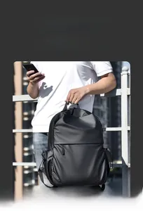Outdoor urban view of a minimalist black commuter laptop backpack on a model