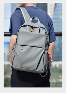 Close-up of gray minimalist backpack with orange zipper details and waterproof fabric