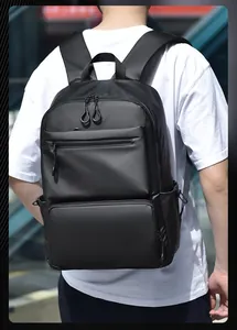 Detail of ergonomic padded straps on a black travel backpack worn by a person