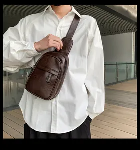 Detail einer Vintage dunkelbraunen Leder-Brusttasche am Modell mit ergonomischem Design