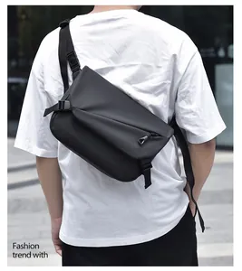 Homme portant un sac à bandoulière noir étanche dans un cadre extérieur urbain moderne